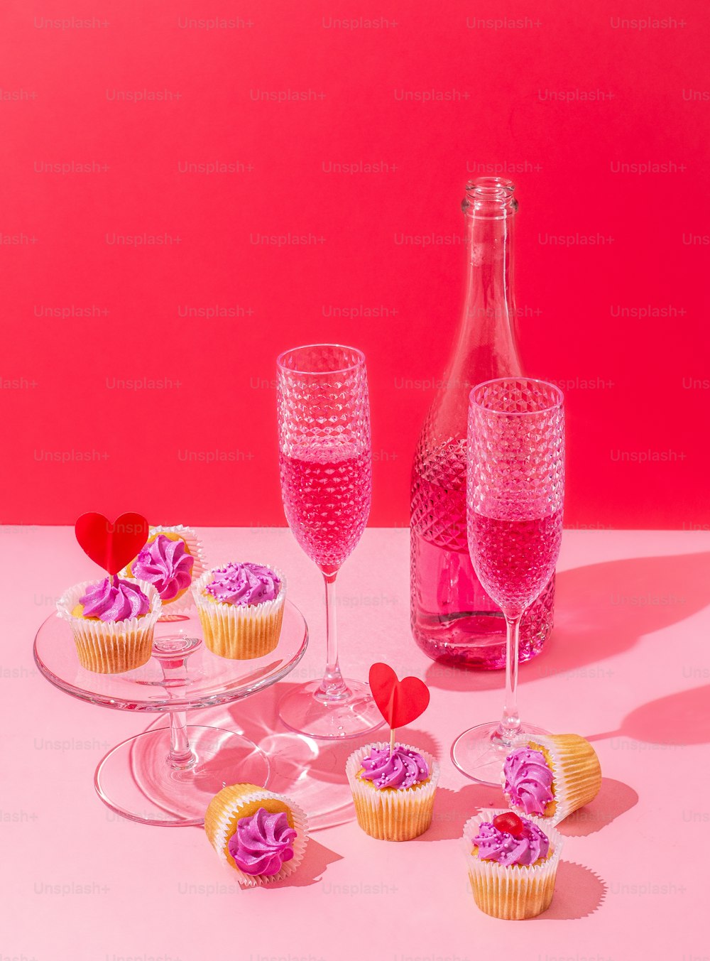 uma mesa coberta com cupcakes e uma garrafa de vinho