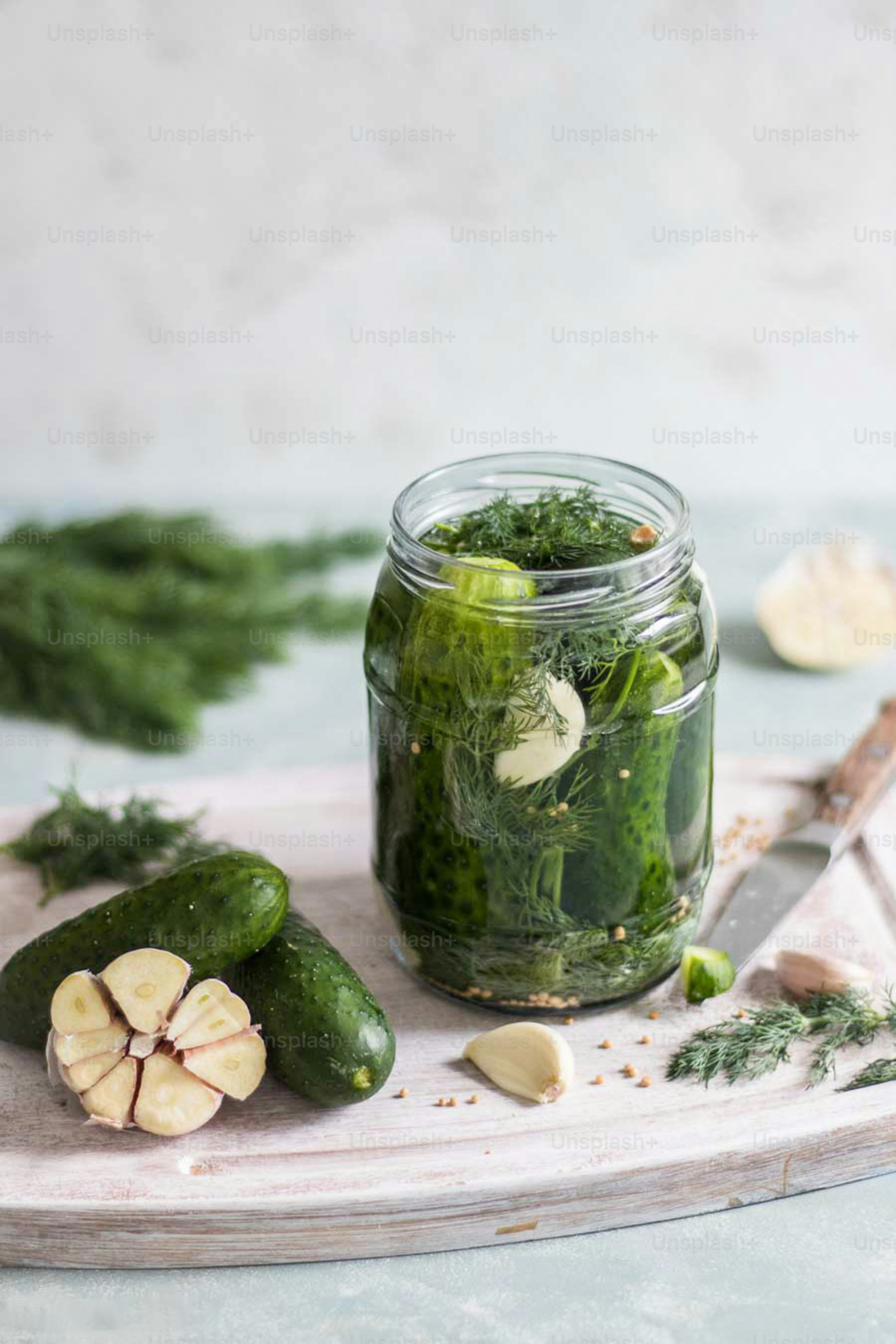 a jar filled with pickles sitting on top of a cutting board