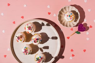 a plate of cupcakes on a pink background