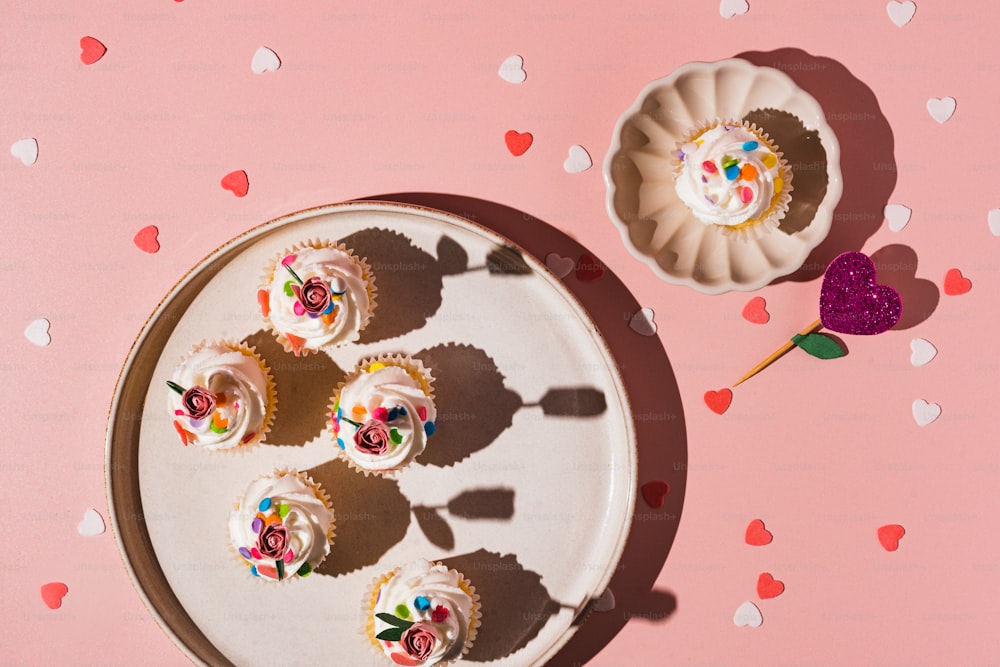 a plate of cupcakes on a pink background