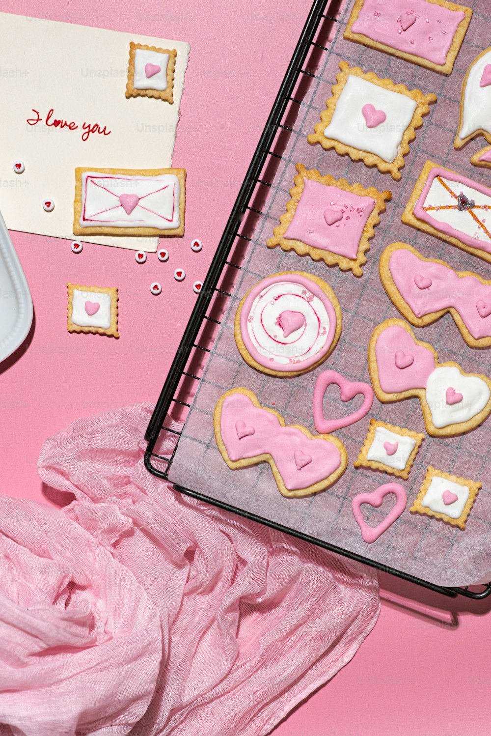 a pink table topped with cookies and a notebook