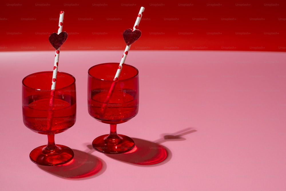 un paio di bicchieri di vino rosso seduti sopra un tavolo