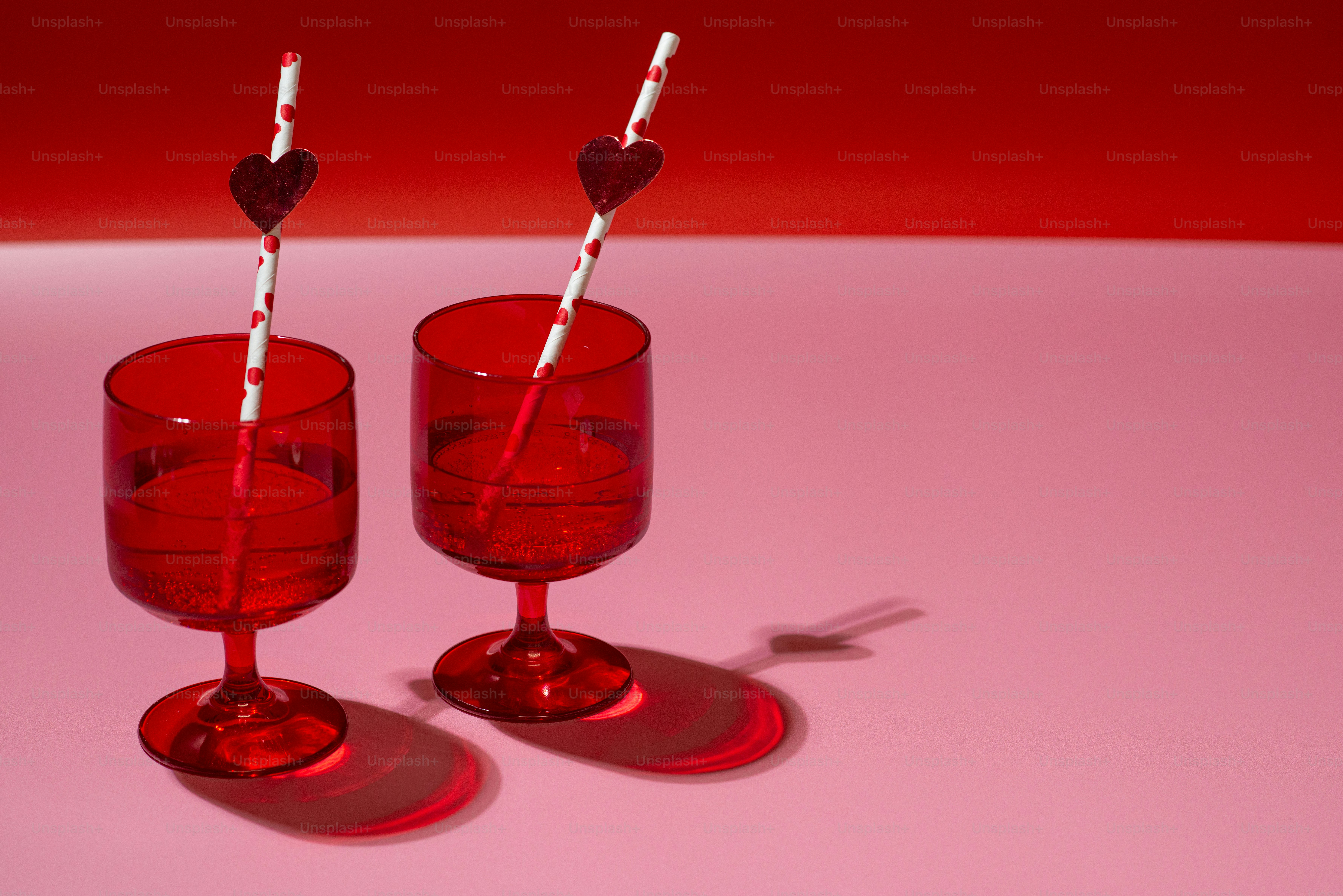 a couple of red wine glasses sitting on top of a table