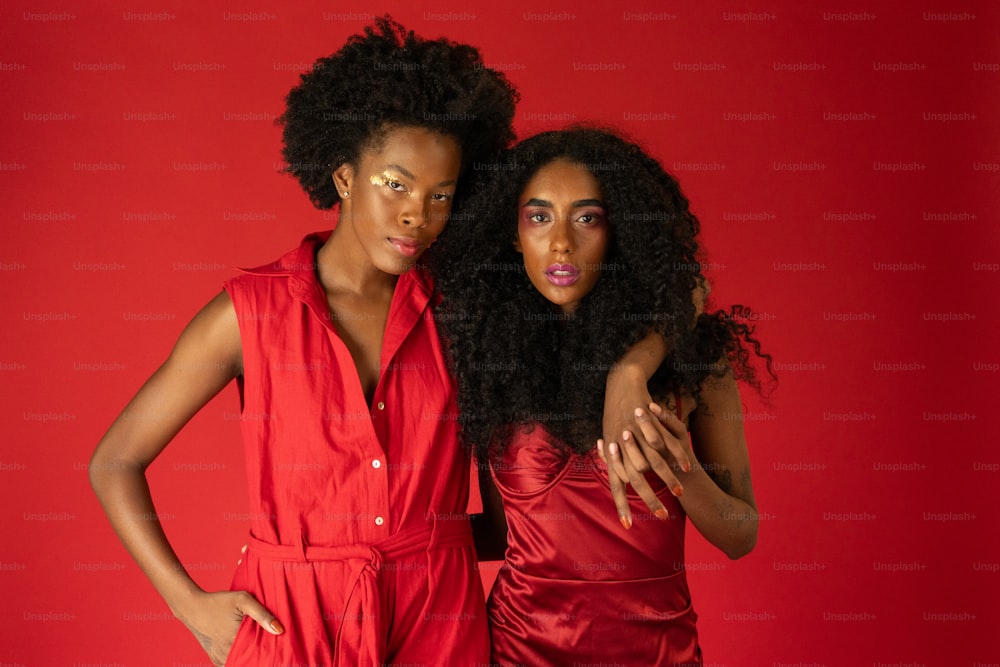 two women in red dresses posing for a picture