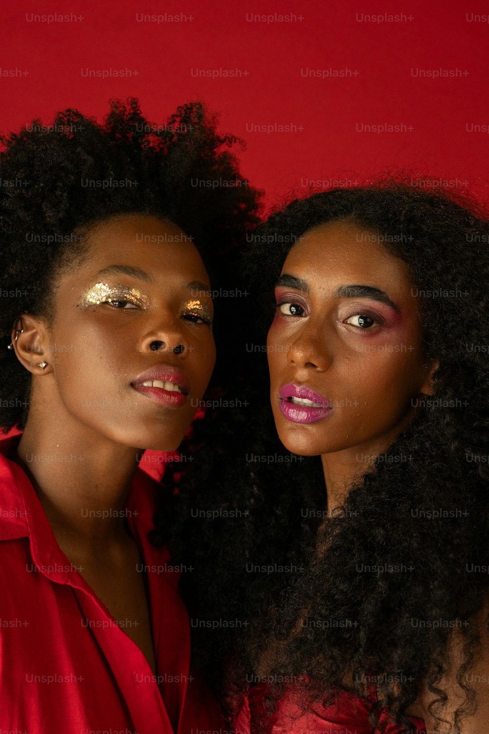 two women with bright makeup are posing for a picture
