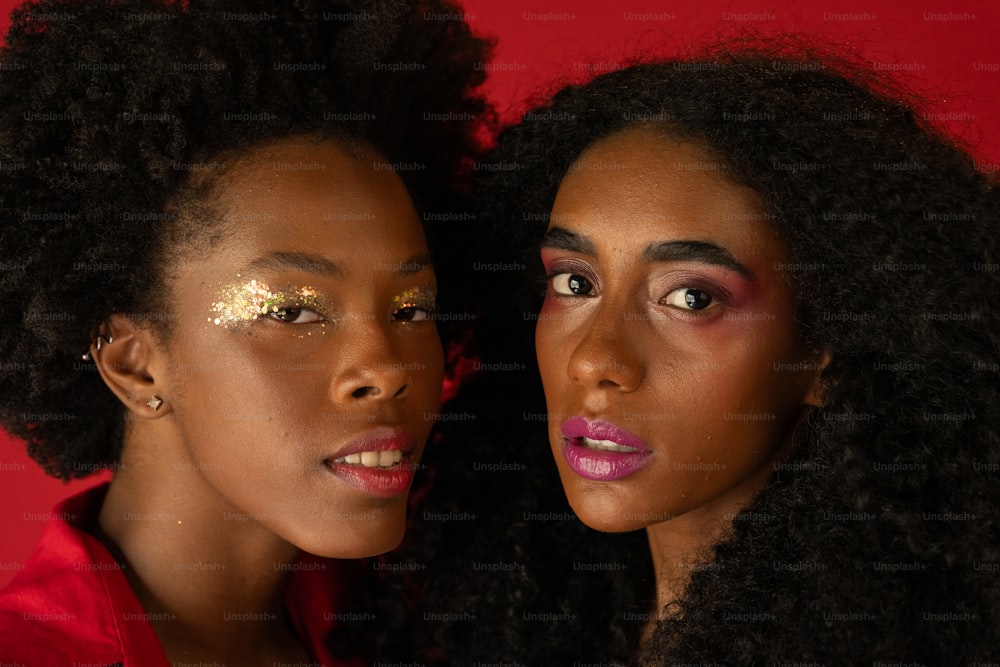 two women with makeup on their faces posing for a picture