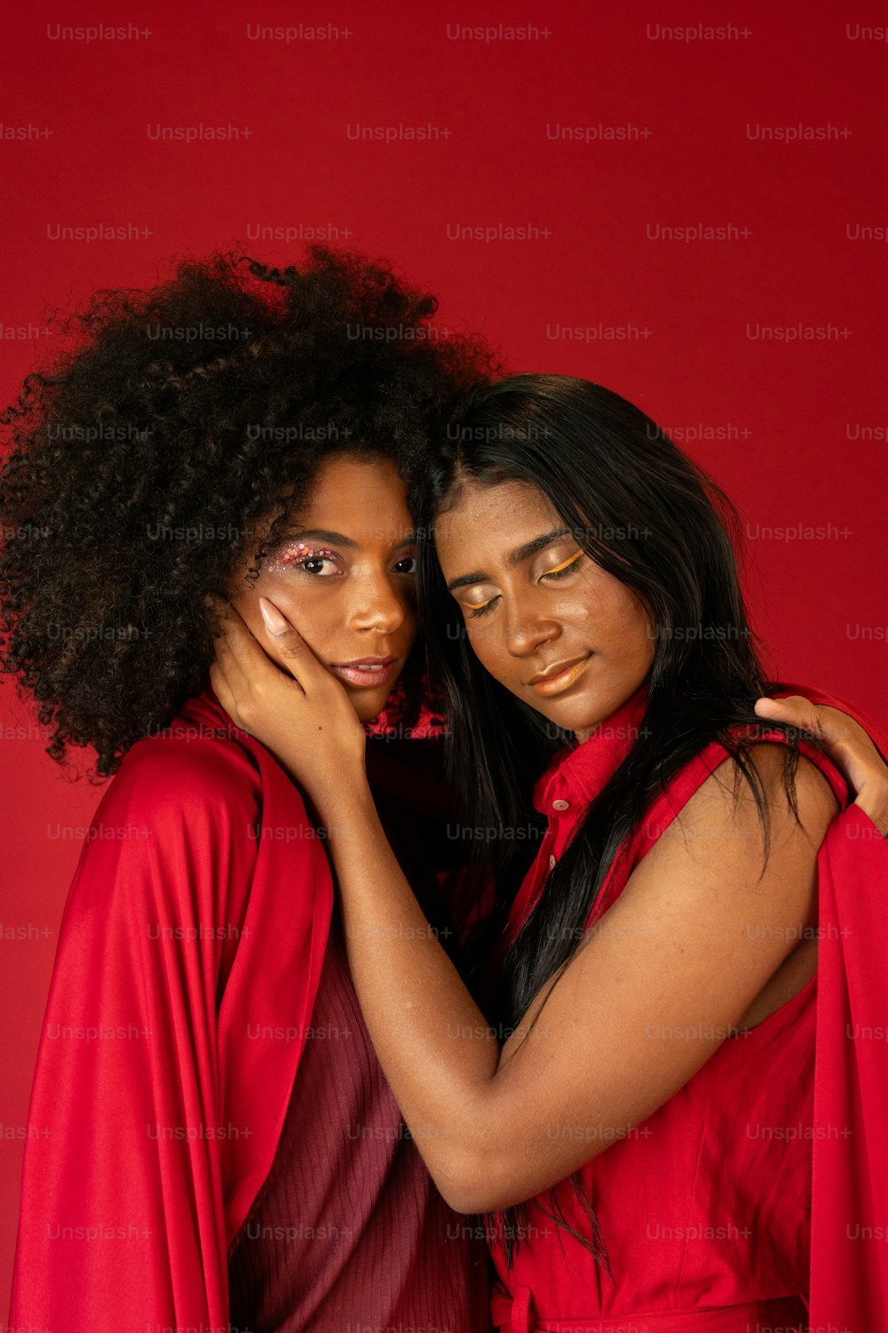 Zwei Frauen in Rot umarmen sich