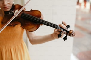 a woman in a yellow dress playing a violin