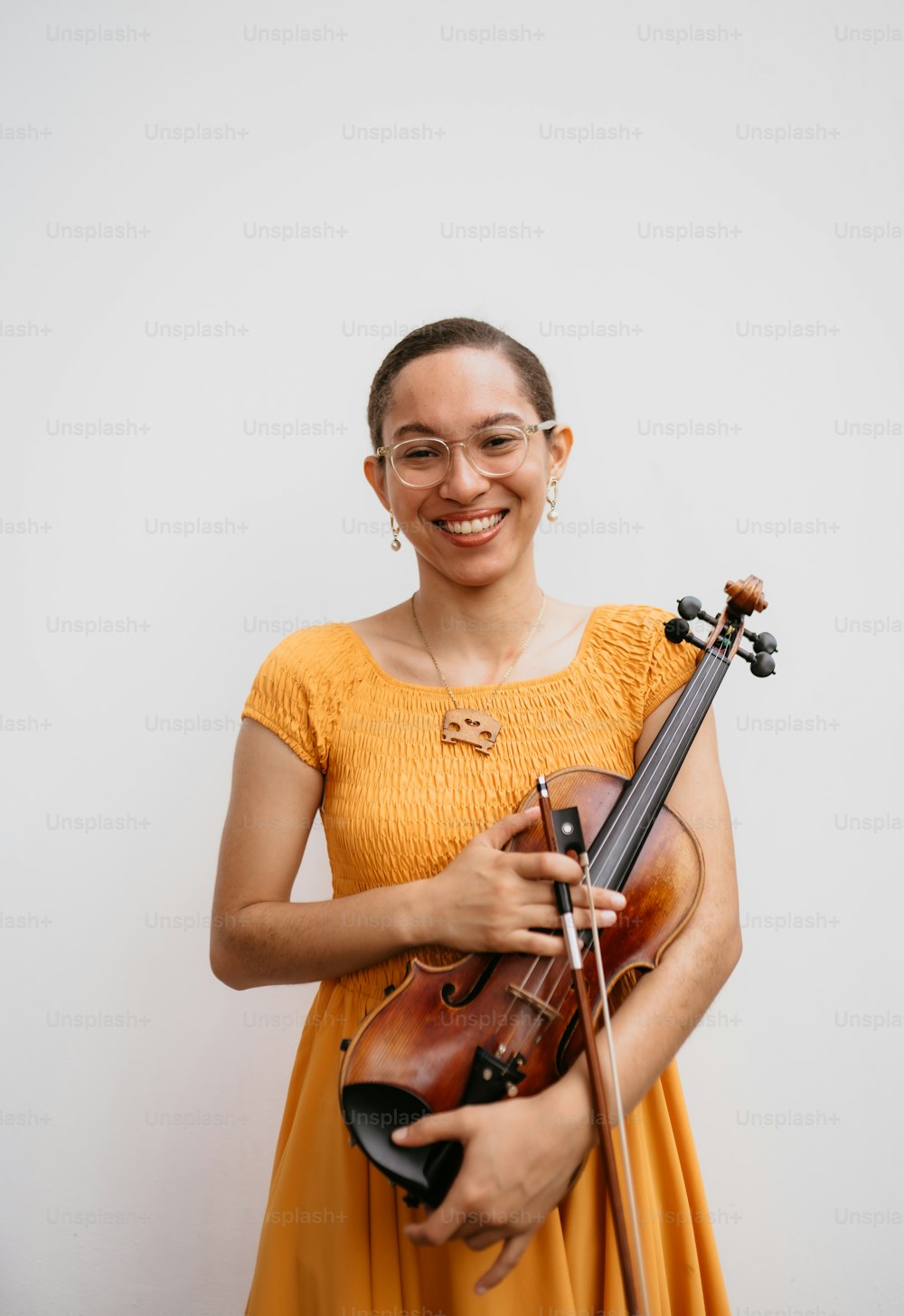 a woman in a yellow dress holding a violin