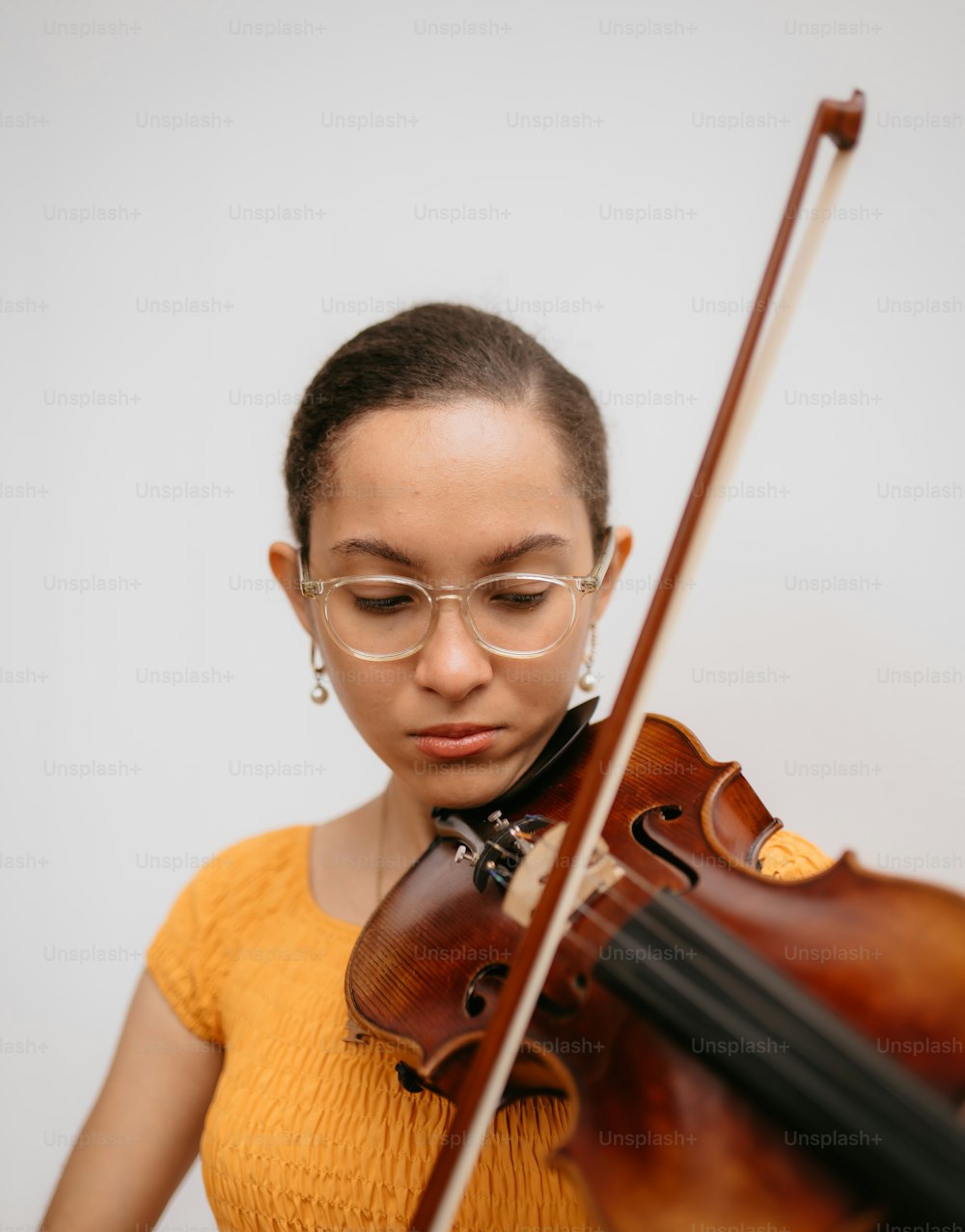 a woman wearing glasses playing a violin