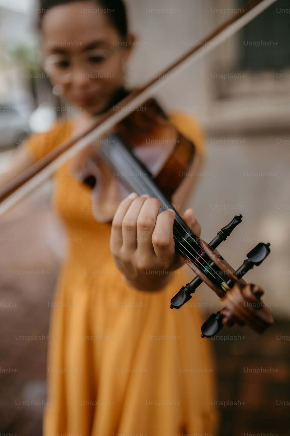 une femme en robe jaune tenant un violon