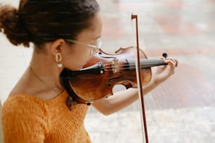 a woman in an orange dress playing a violin
