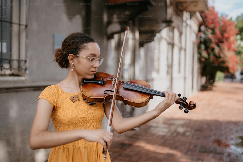 una donna in un vestito giallo che suona un violino