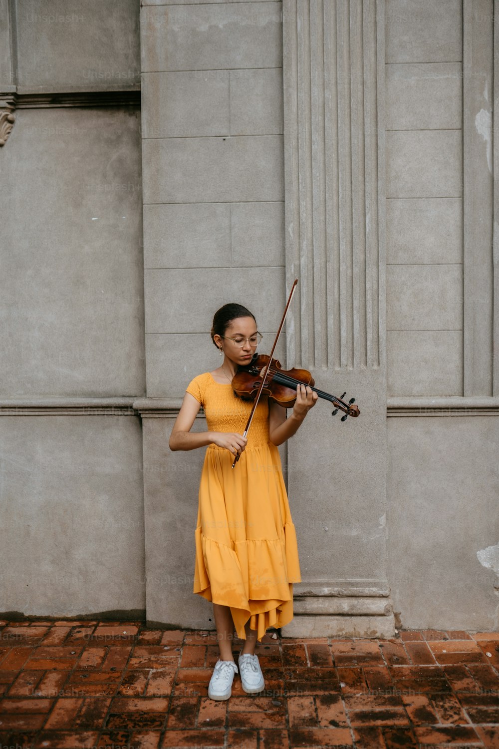 uma mulher em um vestido amarelo segurando um violino
