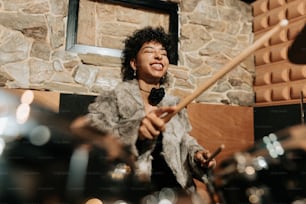 a woman is playing drums in a room