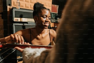 a woman in a black tank top is holding a piece of wood