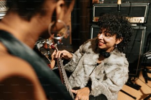 a woman in a fur coat playing a bass