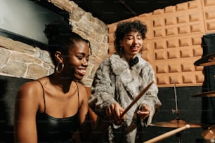 two women playing drums in a recording studio