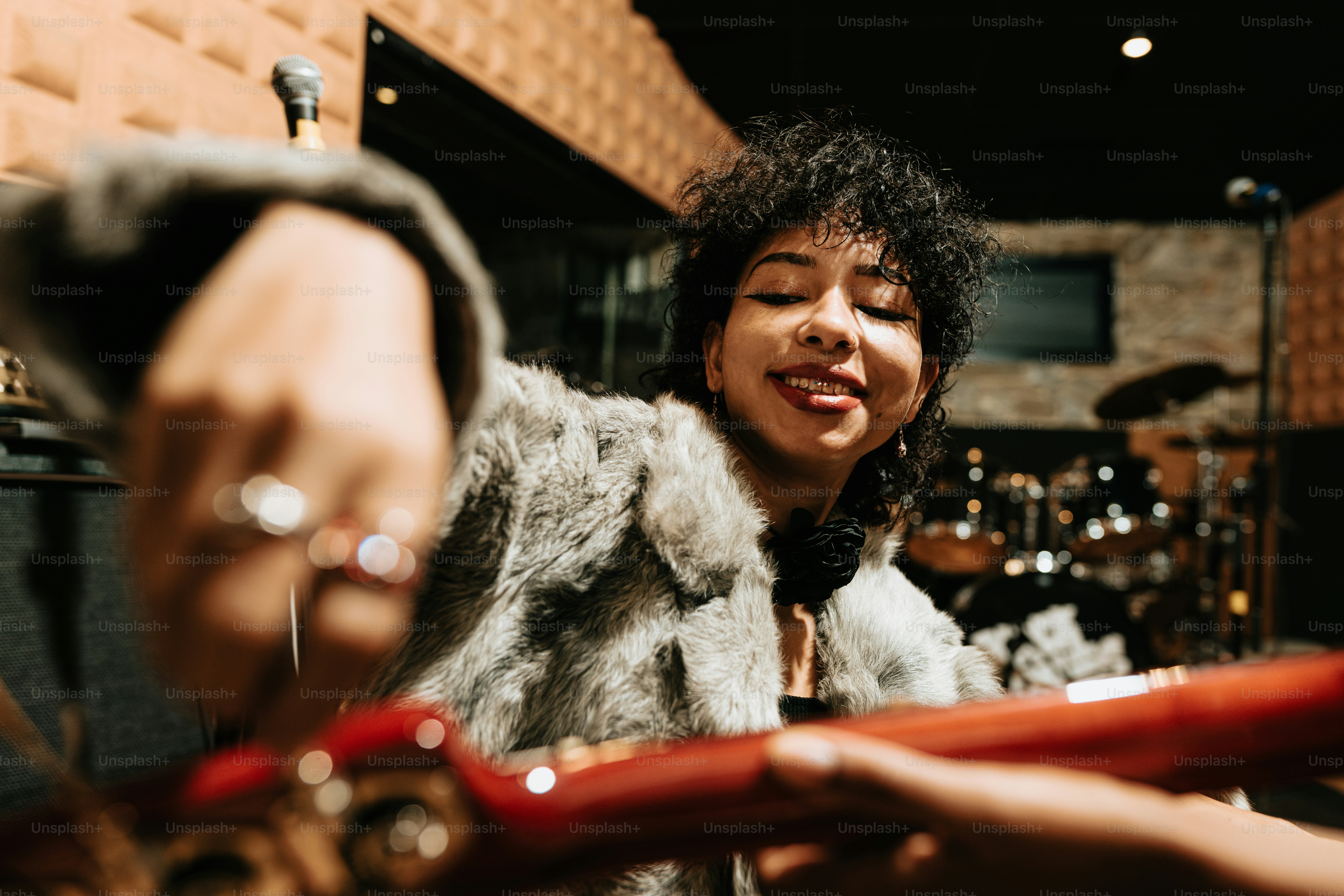A woman in a fur coat playing a musical instrument photo – Rehearsal ...