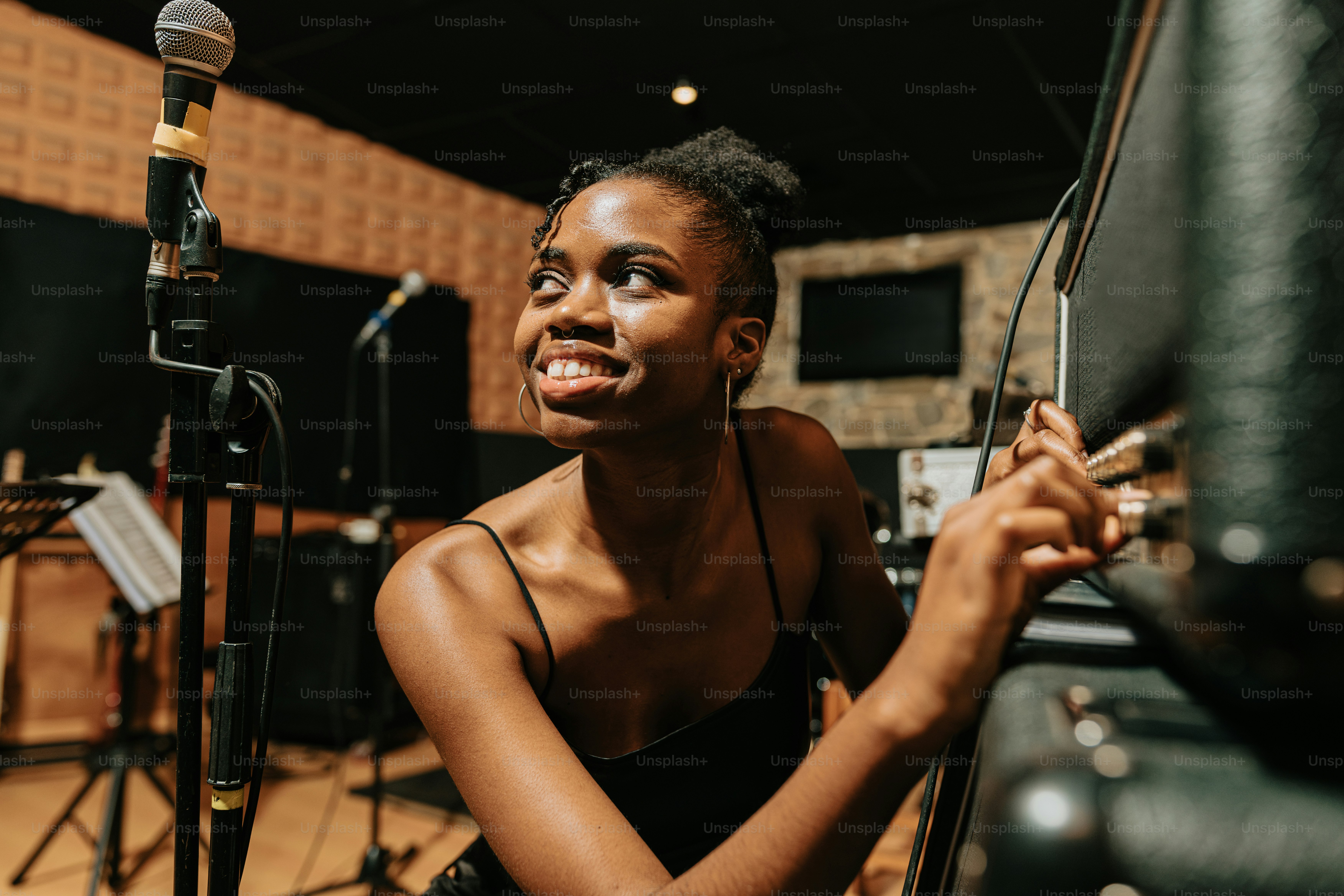 a woman sitting in front of a microphone in a recording studio
