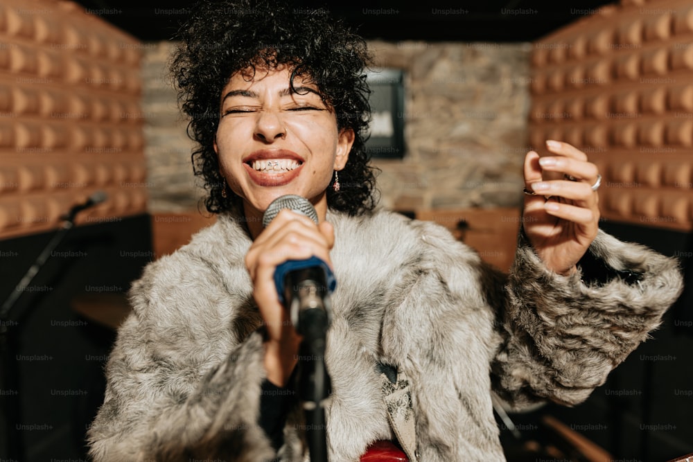 una mujer con un abrigo de piel cantando en un micrófono