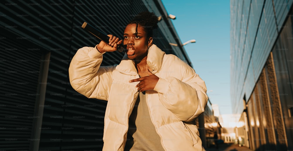 a woman in a white jacket singing into a microphone