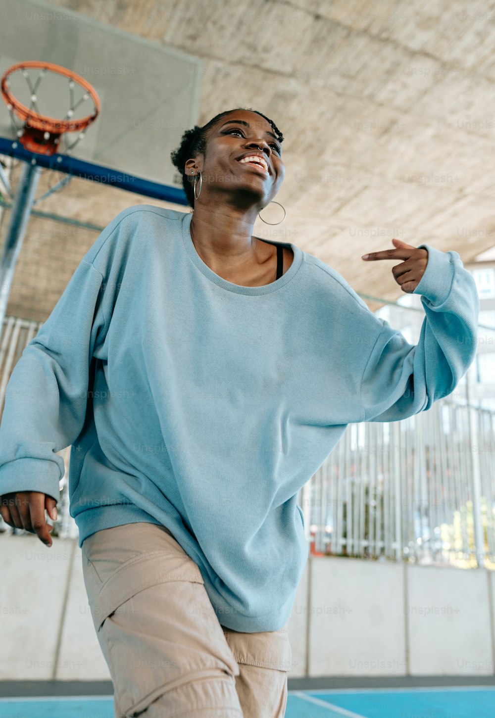 a woman standing on a basketball court holding a basketball