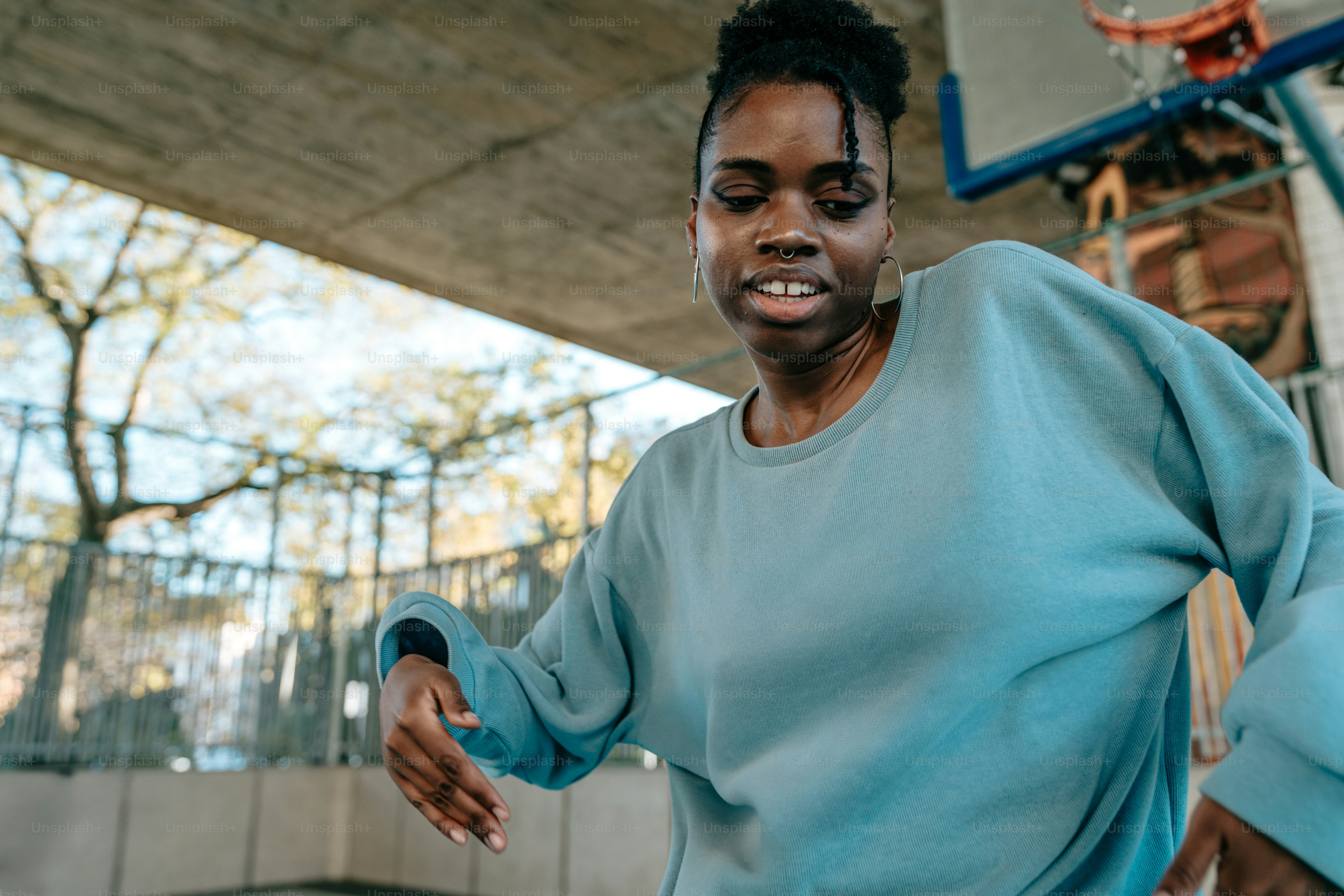eine Frau in einem blauen Sweatshirt mit einem Basketball