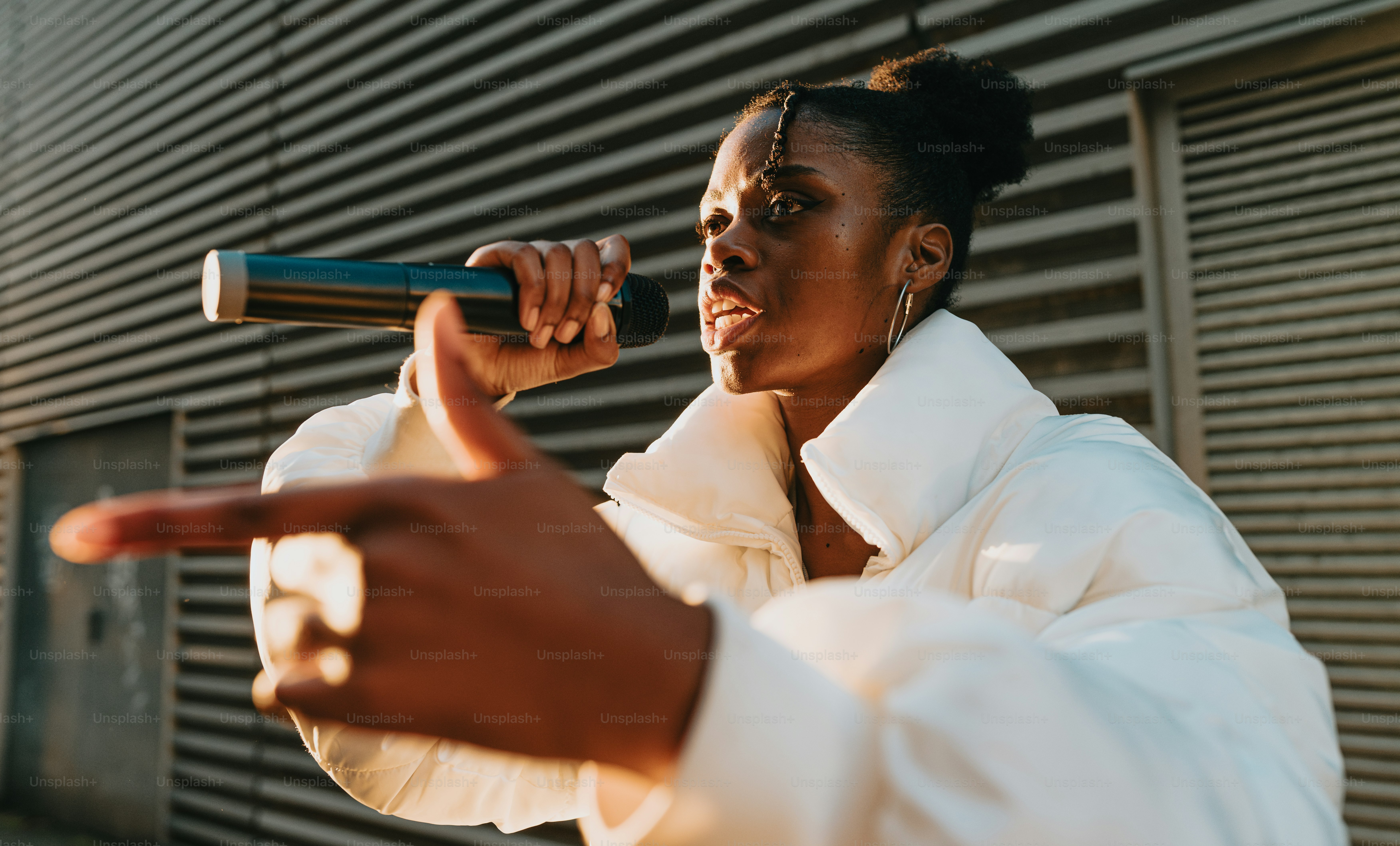 A woman in a white jacket holding a microphone photo – Dancer Image on ...