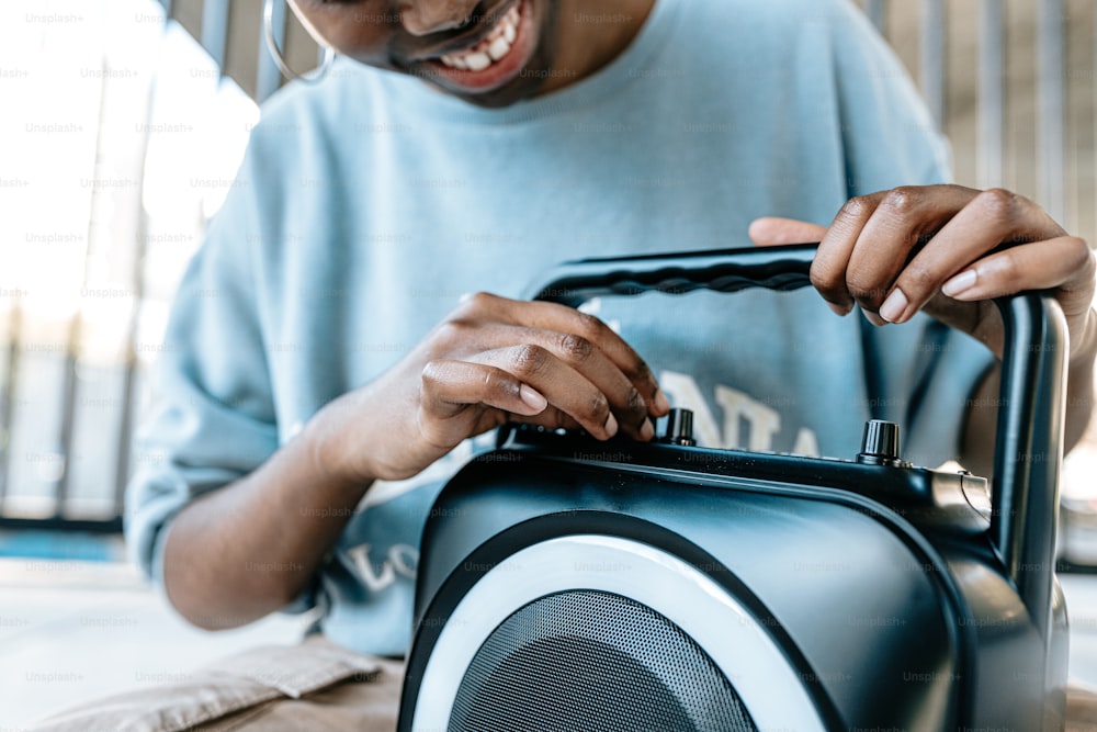 a man holding a blue and white portable speaker