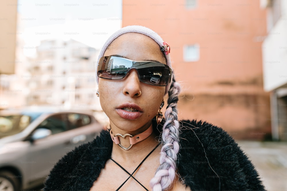 a woman wearing sunglasses and a braid in front of a car