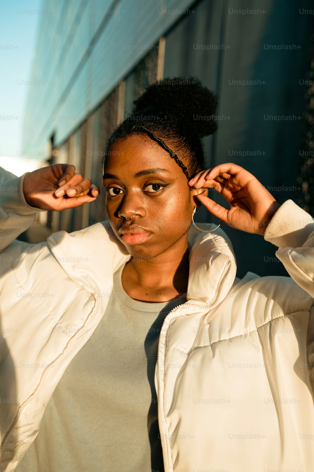 a woman in a white jacket is posing for a picture