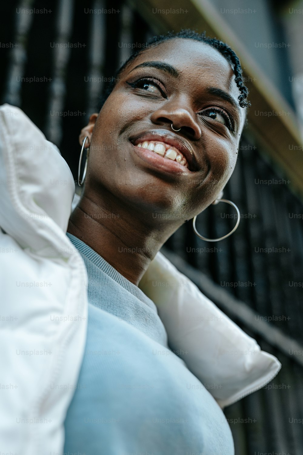 a woman with large hoop earrings smiles at the camera