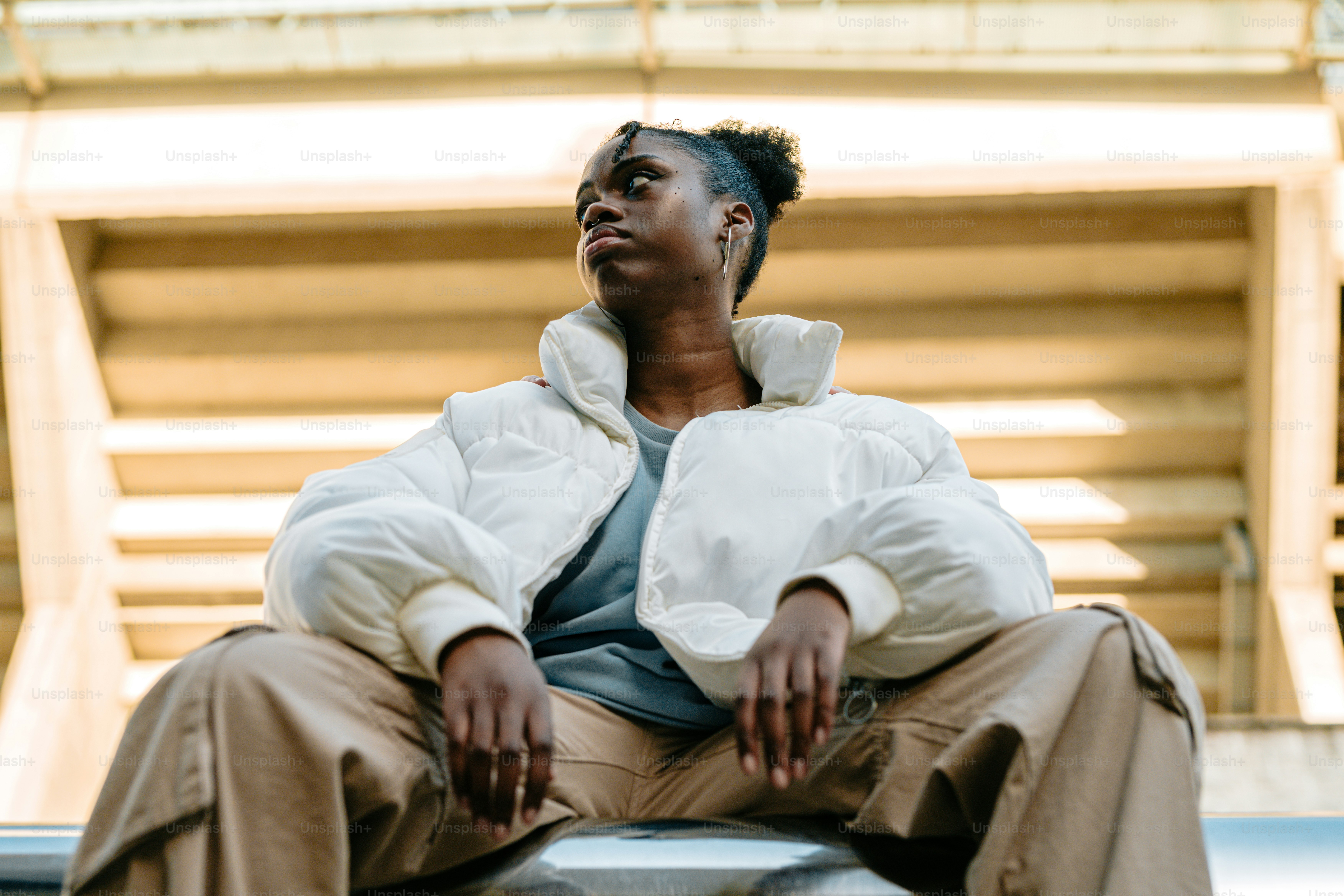 a woman sitting on top of a metal bench