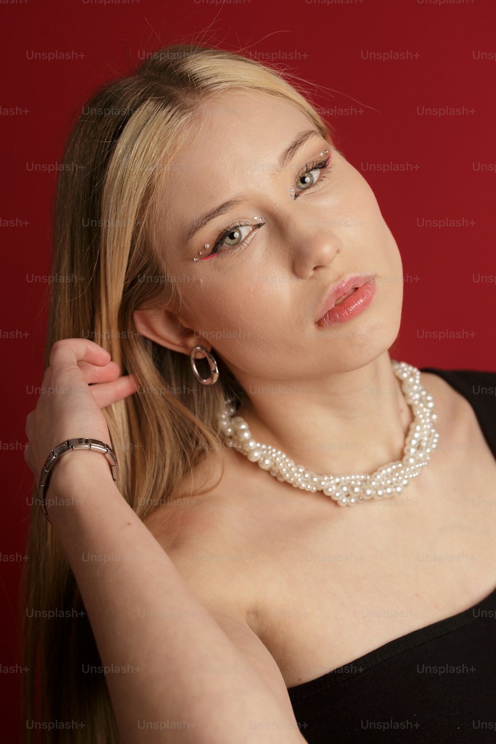 a woman in a black dress with a pearl necklace