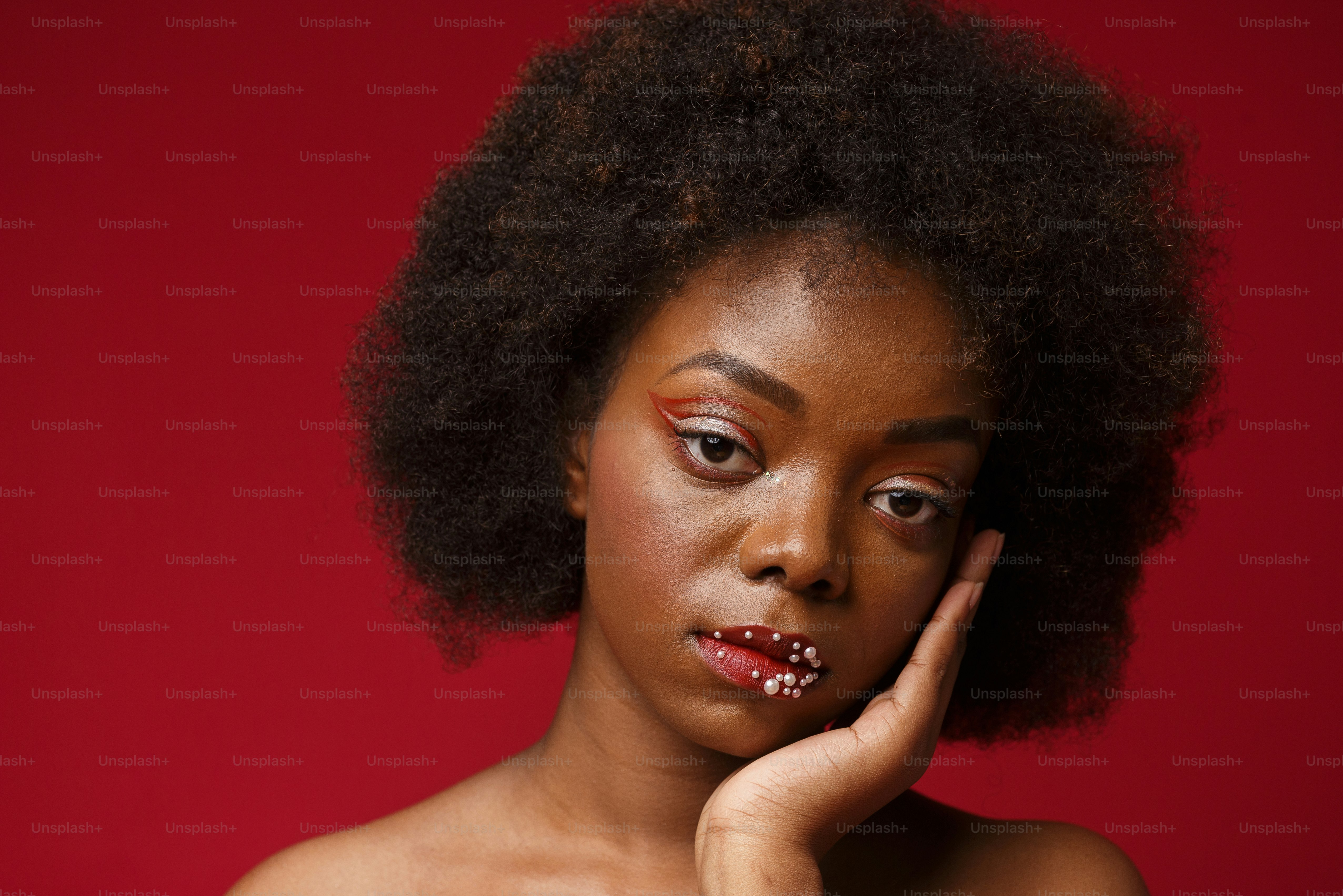 una donna con trucco rosso e uno sfondo rosso