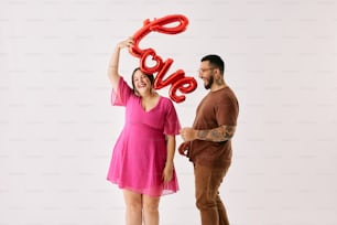 a man and a woman holding up a red love balloon