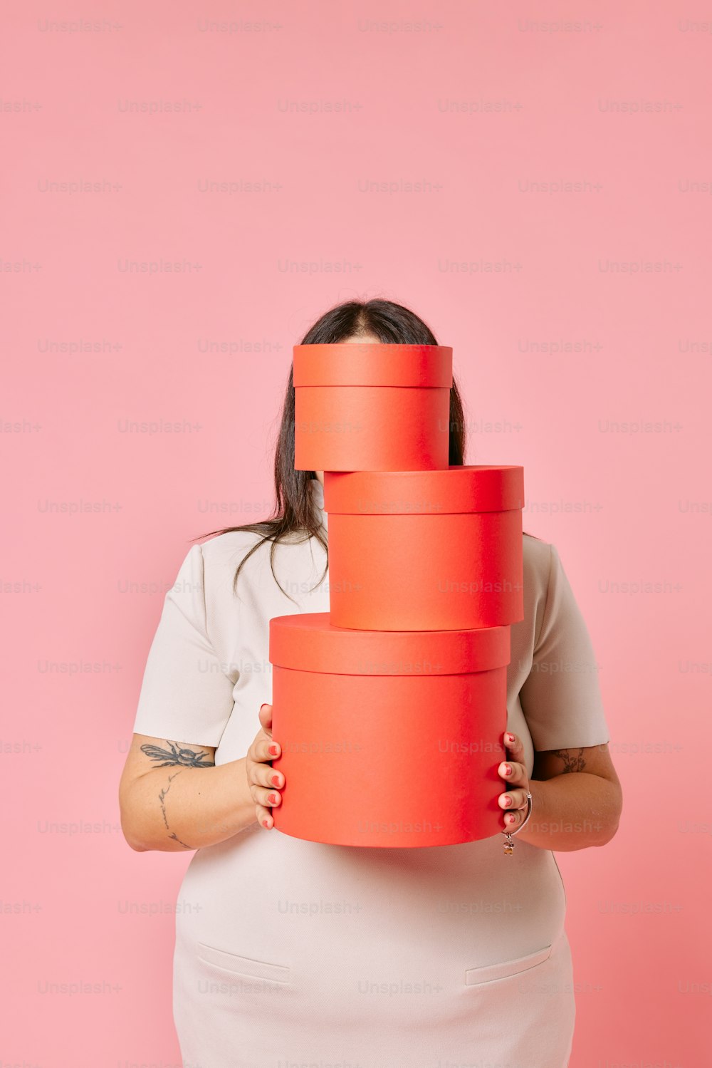 a woman holding a stack of red paper plates