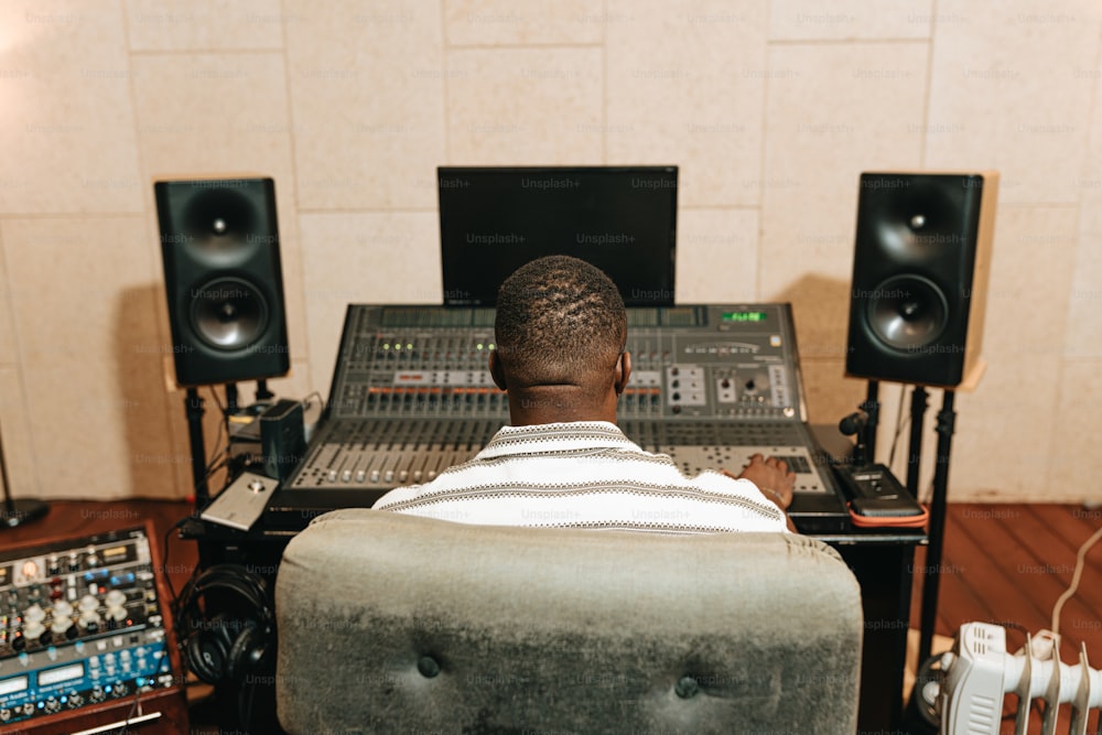 a man sitting in front of a mixing desk