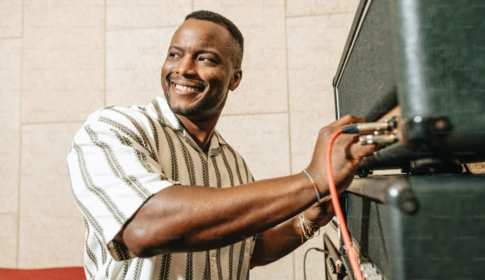 a man is smiling while holding a speaker
