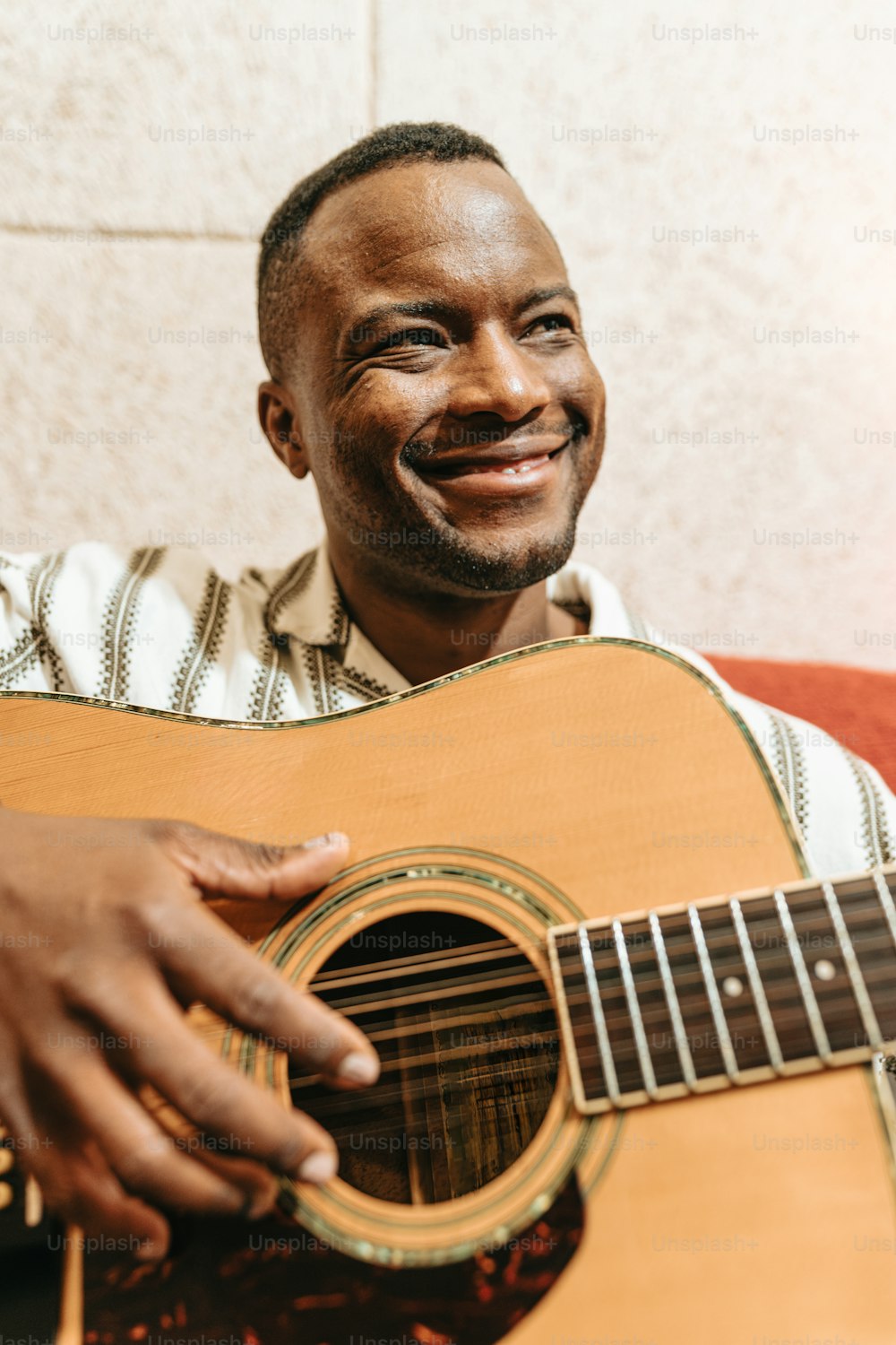a man holding a guitar and smiling at the camera