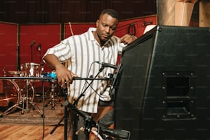 um homem parado em frente a um monitor em um estúdio de gravação