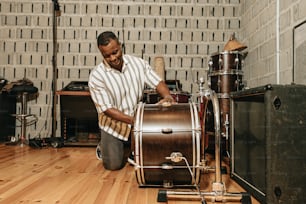 a man sitting on the floor next to a drum set