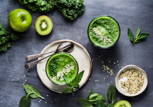 a couple of bowls filled with green smoothies