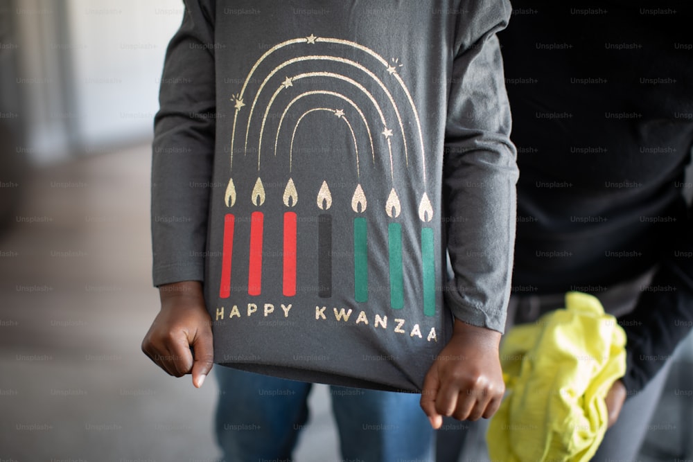 a person holding a t - shirt with candles on it