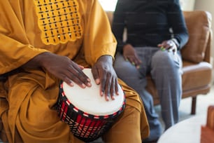 a person sitting on a chair with a drum