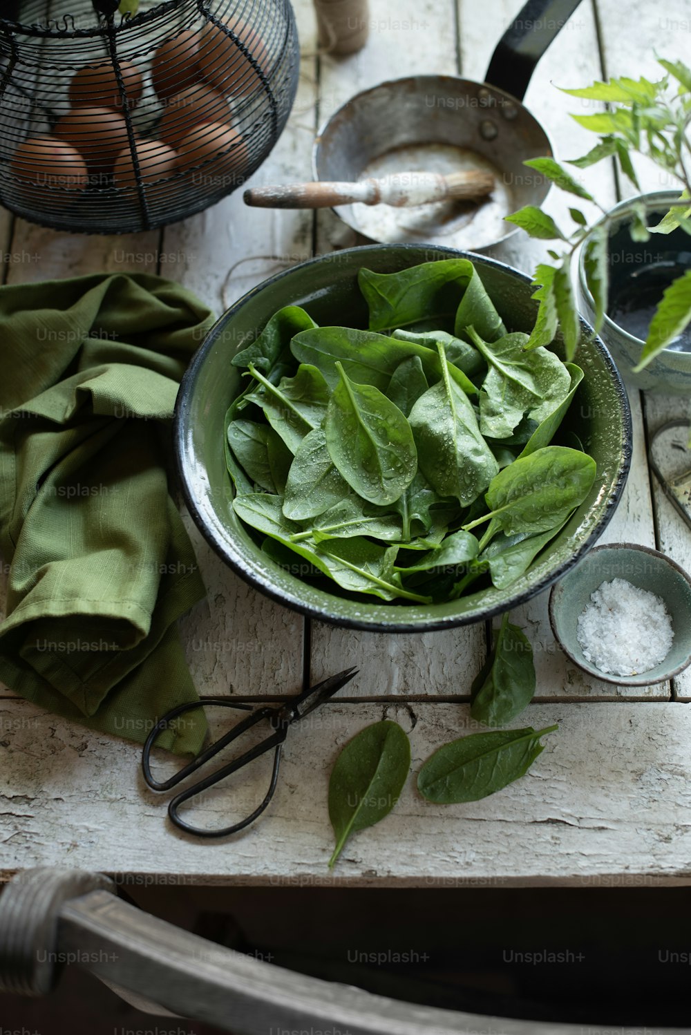 a bowl of spinach leaves on a table
