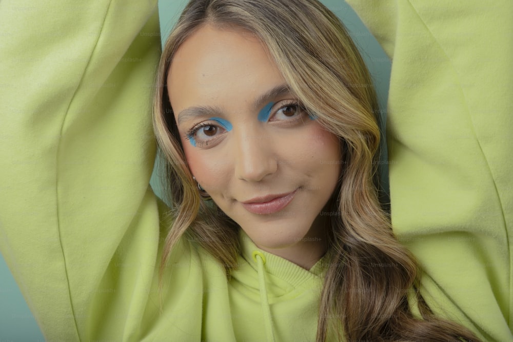 a woman with blue eyes and a green shirt