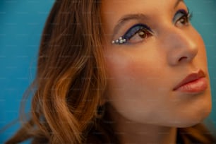 a close up of a woman with blue eye makeup