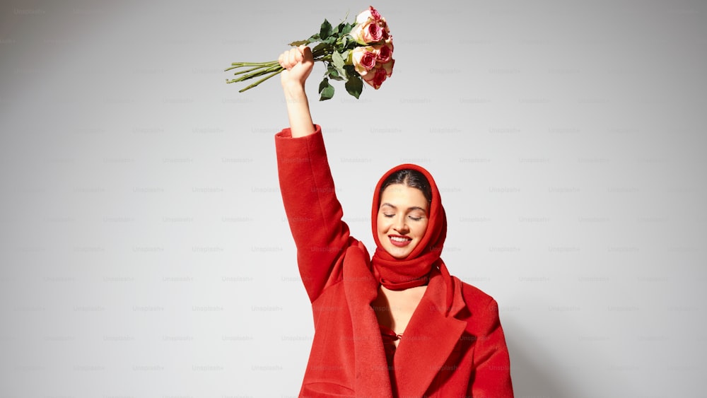 a woman in a red coat holding a bouquet of flowers